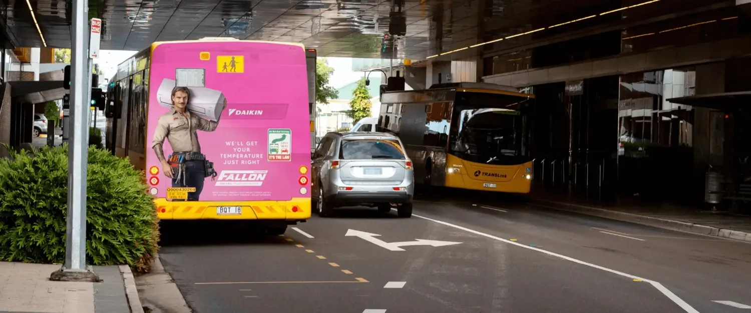 Bright pink bus advertisement for Creative Outpost's Hot Tradie Campaign on an urban street.