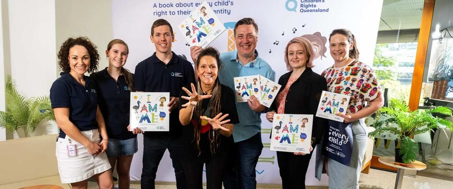 Group of diverse individuals proudly showcasing the I AM ME book, promoting inclusivity and identity.