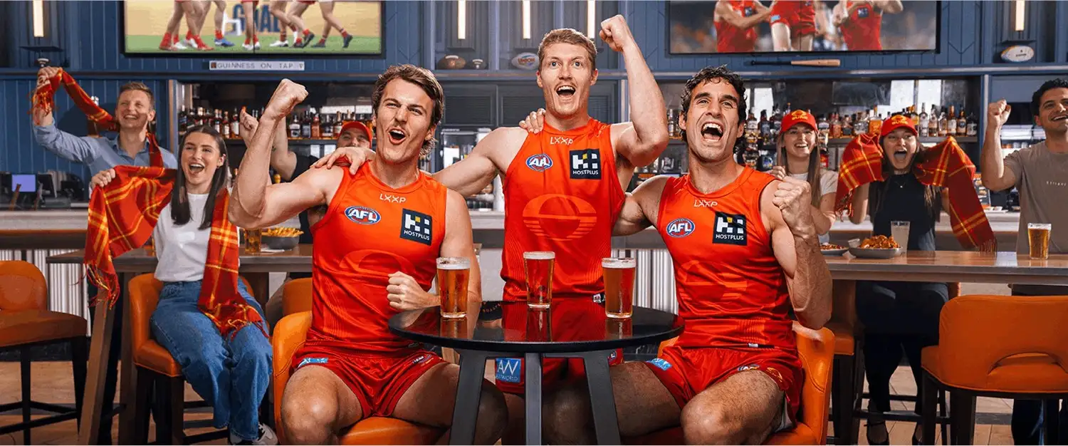 Creative Outpost fans celebrate a game in a lively bar, showcasing team spirit and camaraderie.